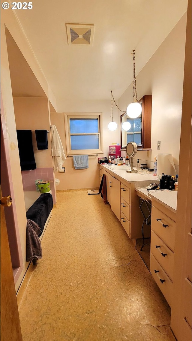 full bathroom with visible vents, toilet, a tub to relax in, and vanity