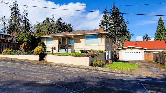 view of front of property with a detached garage, fence, and a chimney