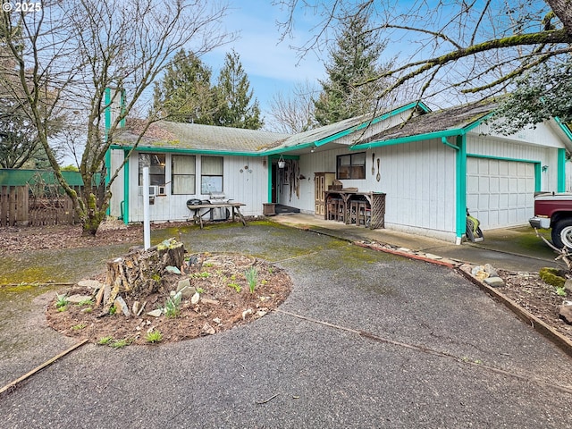 ranch-style home with fence, a garage, and driveway