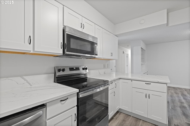 245 NE 4th Ave, Hillsboro, OR 97124 - kitchen with stainless steel appliances, light wood-style flooring, white cabinetry, and a peninsula