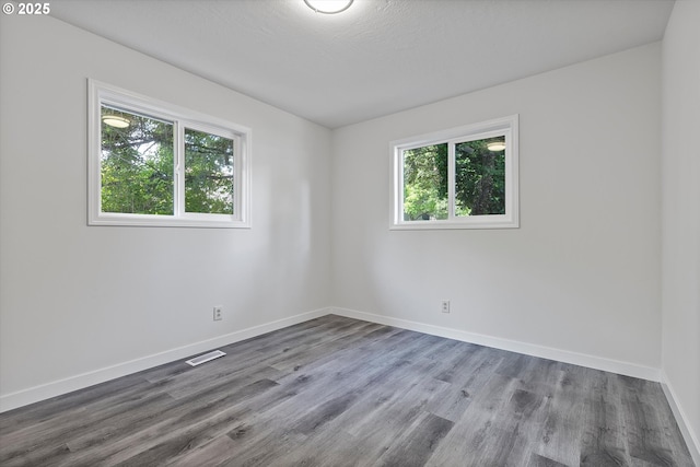 245 NE 4th Ave, Hillsboro, OR 97124 - empty room with healthy amount of natural light, baseboards, and wood finished floors