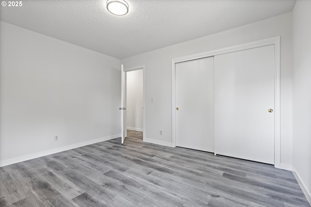245 NE 4th Ave, Hillsboro, OR 97124 - unfurnished bedroom featuring wood finished floors, a closet, a textured ceiling, and baseboards