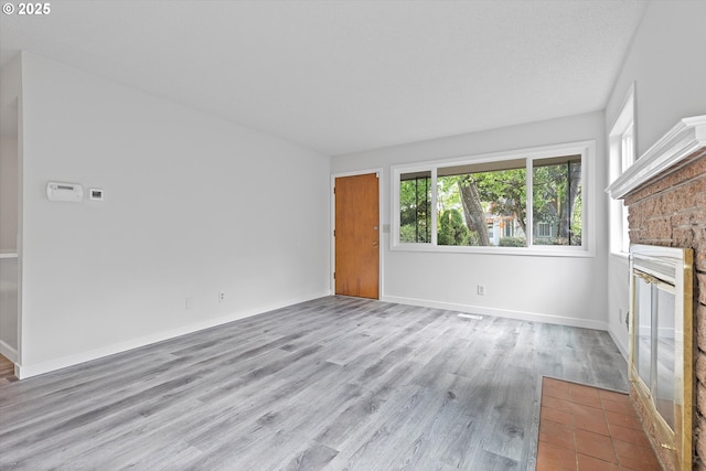 245 NE 4th Ave, Hillsboro, OR 97124 - unfurnished living room with a fireplace, wood finished floors, and baseboards