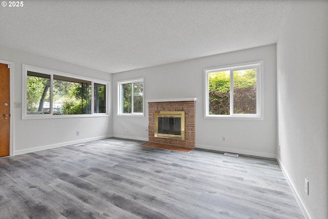 245 NE 4th Ave, Hillsboro, OR 97124 - unfurnished living room featuring healthy amount of natural light, wood finished floors, a textured ceiling, and baseboards