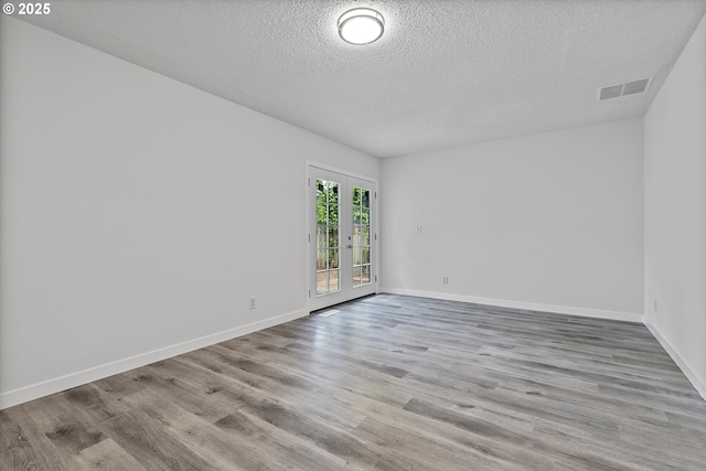 245 NE 4th Ave, Hillsboro, OR 97124 - empty room with a textured ceiling, wood finished floors, baseboards, and french doors