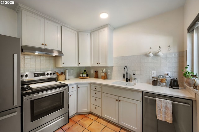 909 NE Brazee St Unit 16, Portland, OR 97212 - kitchen featuring stainless steel appliances, under cabinet range hood, light countertops, and backsplash