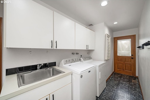 laundry area featuring washer and dryer, cabinets, and sink