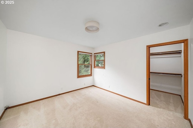 unfurnished bedroom featuring light colored carpet and a closet