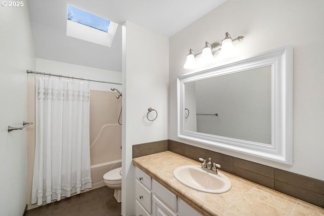 full bathroom with vanity, a skylight, tile patterned flooring, toilet, and shower / tub combo with curtain