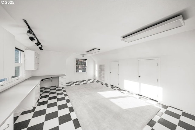 interior space featuring rail lighting and lofted ceiling