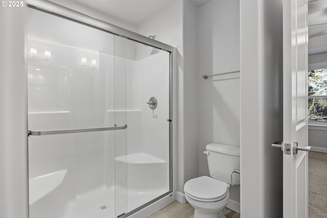 full bathroom with baseboards, a shower stall, and toilet