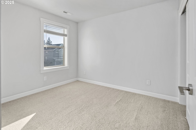 unfurnished room with visible vents, baseboards, and carpet flooring