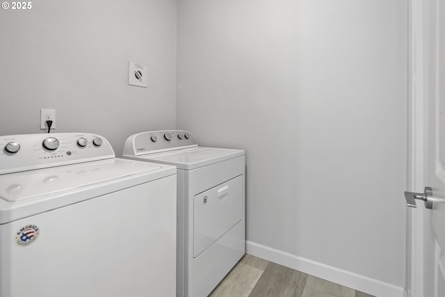 laundry room featuring baseboards, laundry area, light wood finished floors, and washer and dryer