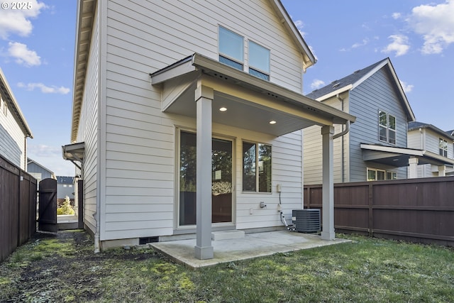 back of house with a patio area, a yard, a fenced backyard, and central AC unit