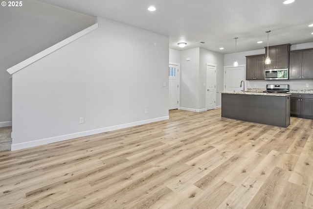 kitchen with stainless steel appliances, light wood-type flooring, a sink, and recessed lighting