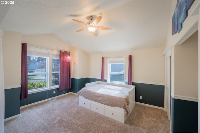 bedroom with lofted ceiling, ceiling fan, visible vents, and carpet flooring