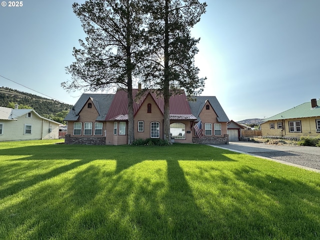 212 NW Bridge St, John Day, OR 97845 - view of front of home with a garage, a front lawn, metal roof, stone siding, and driveway