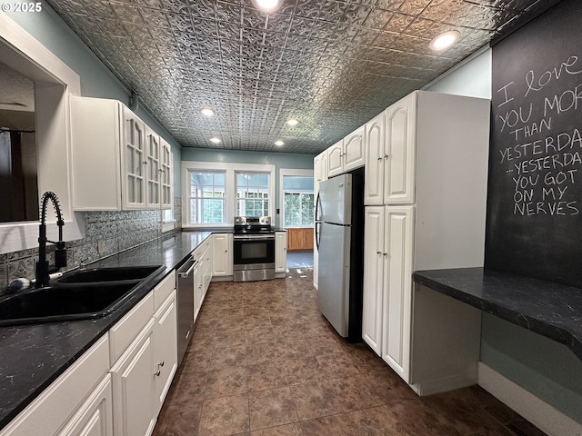 212 NW Bridge St, John Day, OR 97845 - kitchen featuring appliances with stainless steel finishes, a sink, an ornate ceiling, white cabinets, and glass insert cabinets