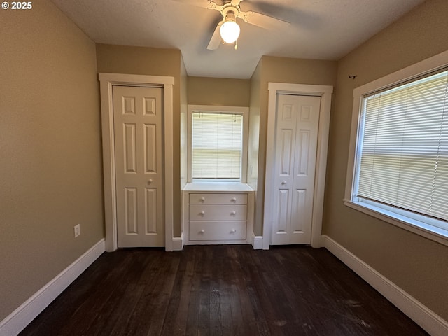 212 NW Bridge St, John Day, OR 97845 - unfurnished bedroom with dark wood-style floors, baseboards, and ceiling fan