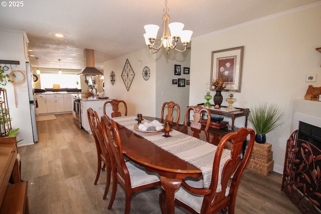 dining space featuring an inviting chandelier, recessed lighting, light wood finished floors, and crown molding