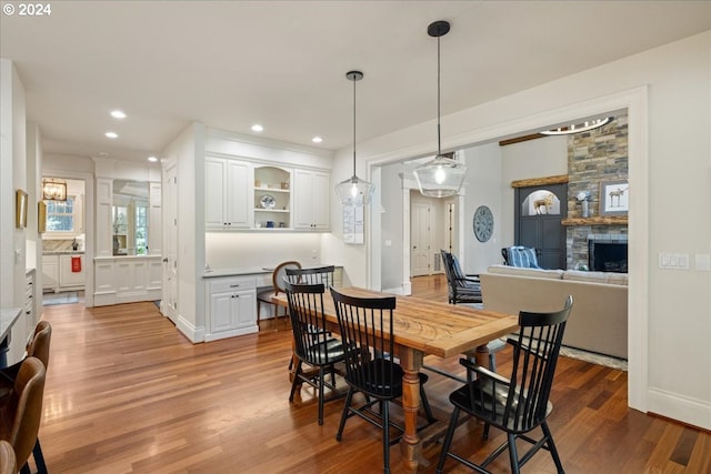 dining space with a fireplace and hardwood / wood-style flooring