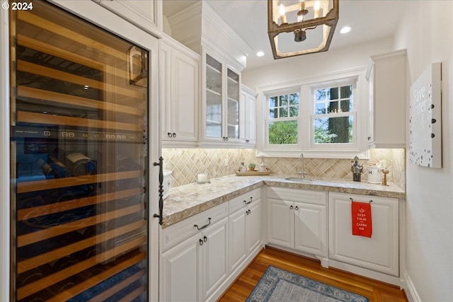 kitchen with white cabinetry, decorative backsplash, and beverage cooler