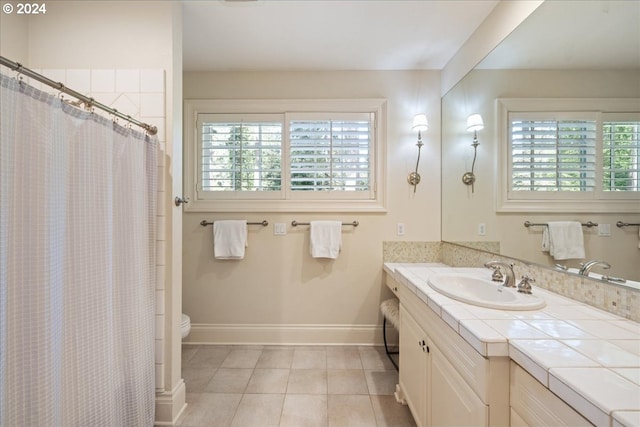 bathroom featuring toilet, vanity, a shower with curtain, and tile patterned flooring