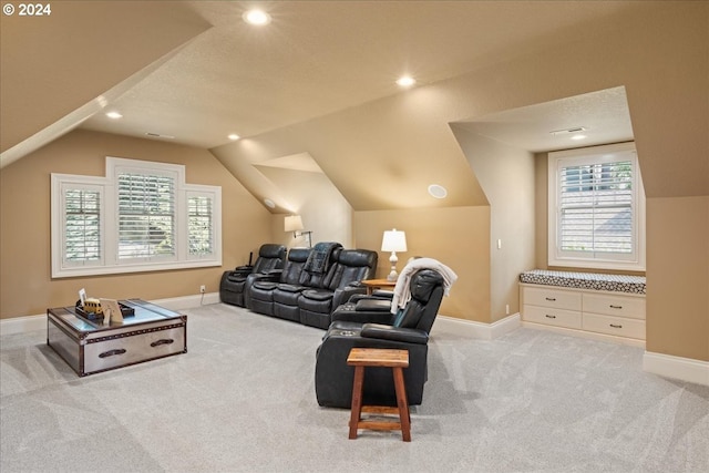 carpeted home theater room featuring a textured ceiling and vaulted ceiling