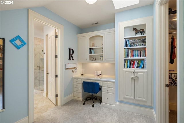 carpeted home office featuring a skylight