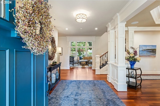 entrance foyer featuring dark hardwood / wood-style flooring, crown molding, and ornate columns