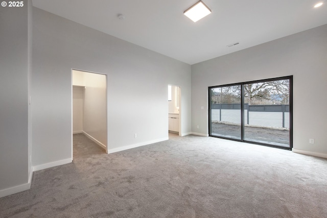 empty room with a towering ceiling and carpet floors