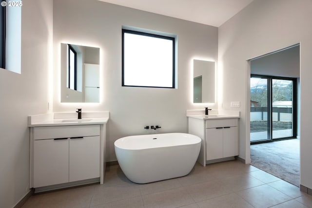 bathroom featuring tile patterned floors, vanity, and a bathing tub