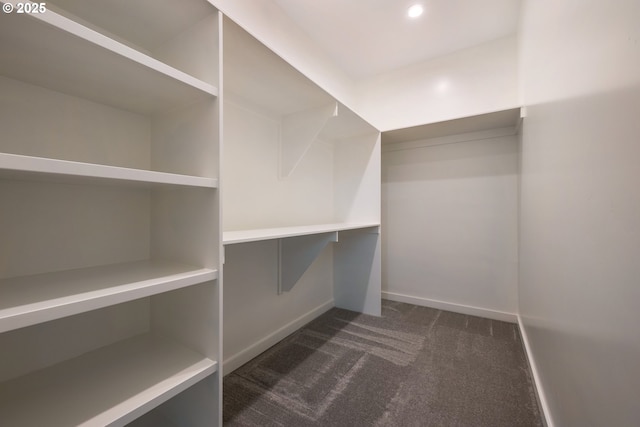 spacious closet featuring dark carpet