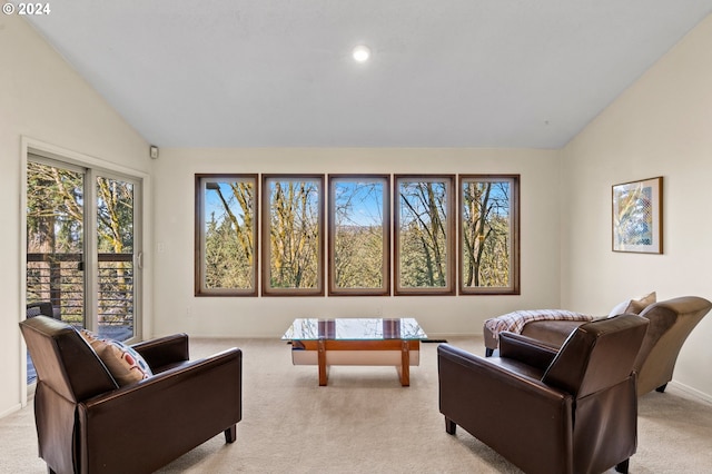 living area featuring baseboards, vaulted ceiling, and light colored carpet