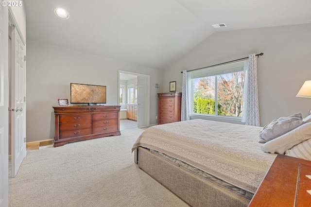 carpeted bedroom featuring visible vents, baseboards, vaulted ceiling, and ensuite bathroom