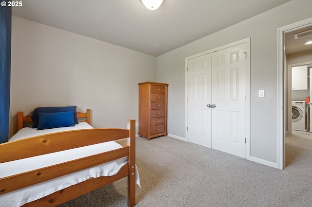 bedroom featuring light carpet, washer / dryer, baseboards, and visible vents