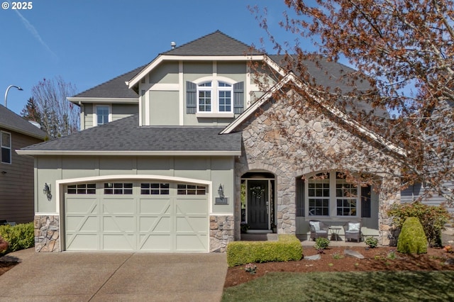 view of front of property featuring a shingled roof, stone siding, stucco siding, and concrete driveway