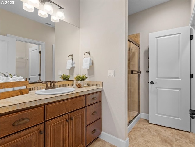 bathroom featuring tile patterned flooring, vanity, a shower with door, and a chandelier