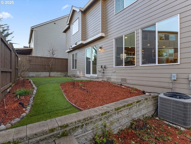 rear view of house featuring a yard and central air condition unit