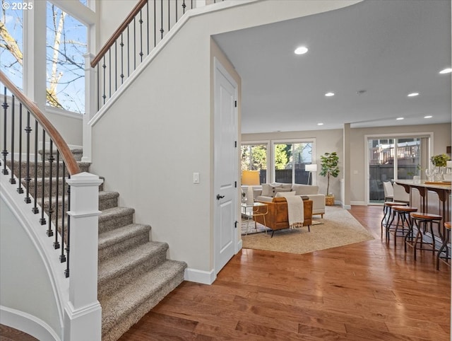 stairs with recessed lighting, baseboards, and wood finished floors