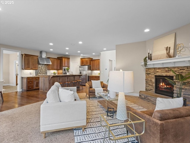 living room featuring a stone fireplace and hardwood / wood-style flooring