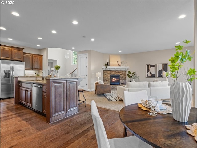 dining space featuring a fireplace, dark hardwood / wood-style flooring, and sink