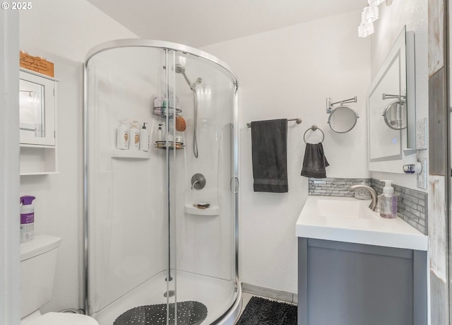 bathroom with tasteful backsplash, vanity, a shower stall, and toilet