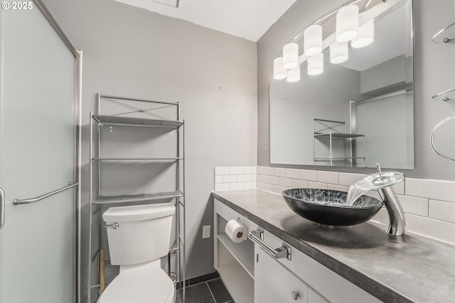 bathroom with a shower with door, decorative backsplash, toilet, and vanity