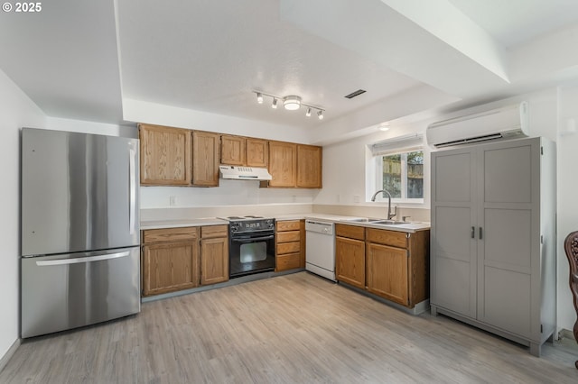 kitchen featuring a wall mounted AC, electric range, freestanding refrigerator, a sink, and dishwasher