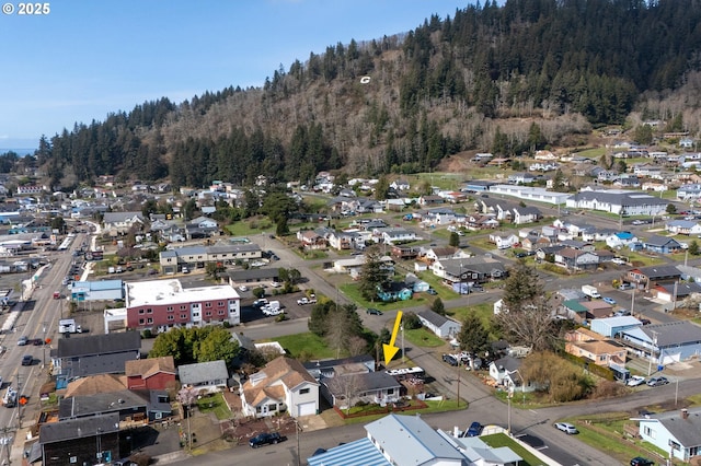 drone / aerial view featuring a residential view and a wooded view