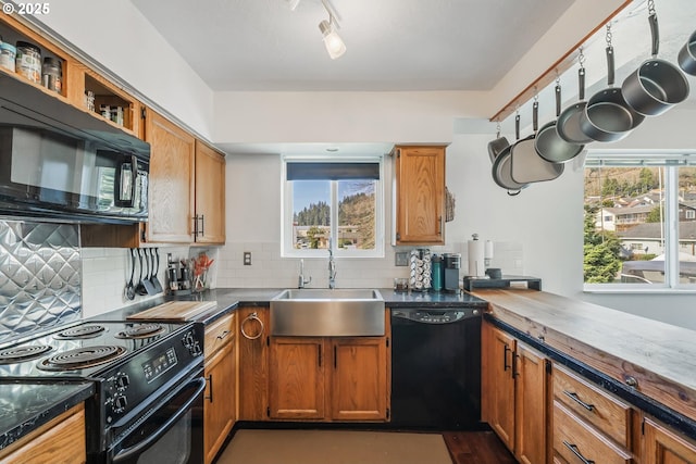 kitchen with a sink, dark countertops, tasteful backsplash, and black appliances