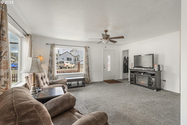 carpeted living room featuring a textured ceiling, a healthy amount of sunlight, and ceiling fan