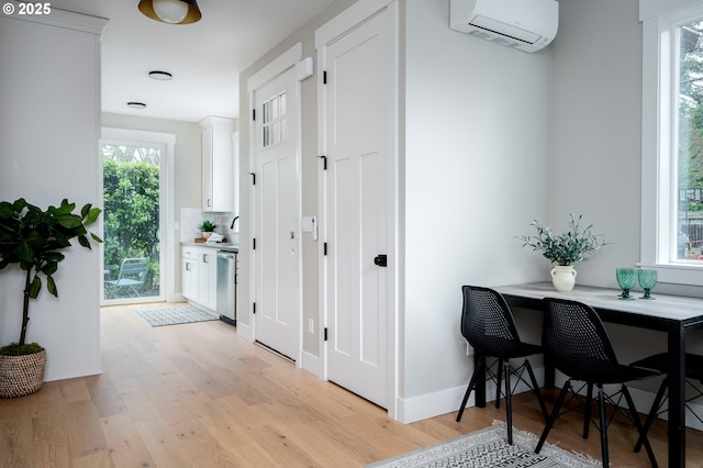 hallway featuring a wall mounted AC and light hardwood / wood-style floors