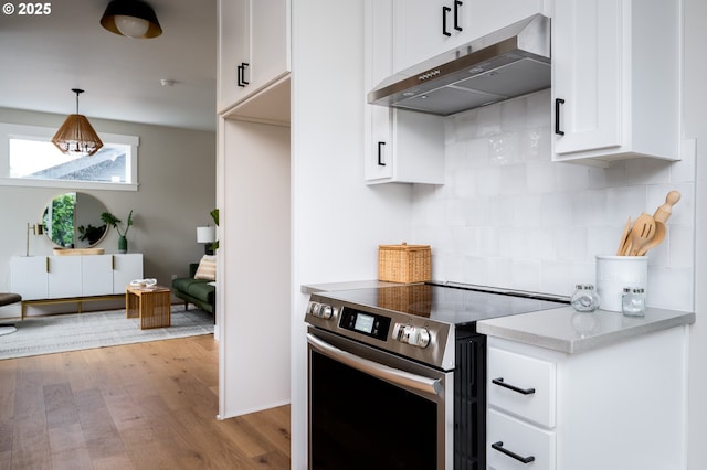 kitchen with white cabinets, stainless steel electric range, wood-type flooring, decorative backsplash, and hanging light fixtures